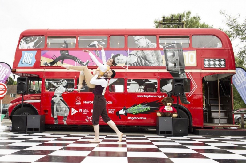 London route-master bus with outdoor dance-floor and dancer in front